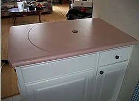 Pink laminate counter on a white cabinet before refinishing