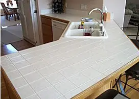 White tile corner counter with grout lines before refinishing