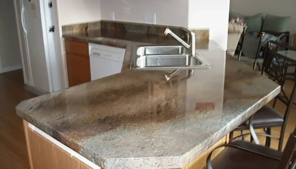 Corner kitchen counter refinished in a brown and cream stone-look overlay beside a steel sink